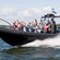 About 15 passengers wave from aboard a speeding Rigid Inflatable Boat